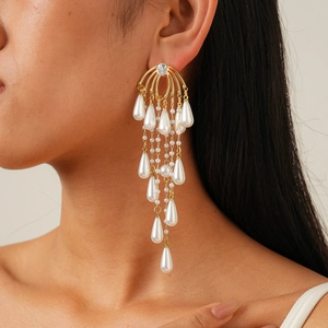 Detailed view of luxury gold tassel earrings with teardrop pearls and zircon stones