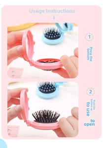 Foldable macaron hairbrush with mirror showing the push-to-open mechanism in pink