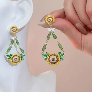 Sunflower and bee drop earrings with yellow oil drip finish and green bead accents