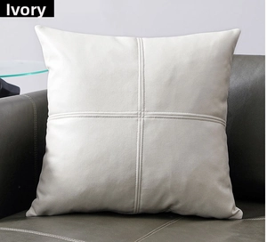 Detail of ivory white throw pillow cover with minimalist cross-stitch sewing on leather