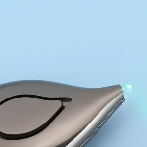 Detail of leaf-shaped dark grey personal alarm with a glowing teal light-up tip