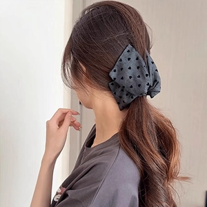 Detail einer großen Haarspange aus grauem Denim mit Herzmuster für langes Haar