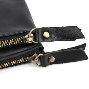 Detail of genuine leather coin pouch with dual vintage brass zippers and leather pulls
