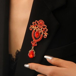 Detail of vintage teardrop red crystal brooch pinned on a black suit lapel