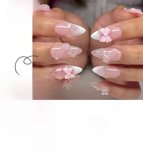 Macro view of pink almond press-on nails with 3D roses, bows, and pearl details