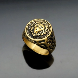 Vintage gold lion head stainless steel signet ring for men on reflective surface