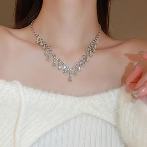 Close-up of sparkling rhinestone teardrop pendant necklace worn on a model neckline