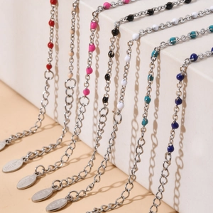 Detail of colorful beads and stainless steel cross bracelets with adjustable extension chains