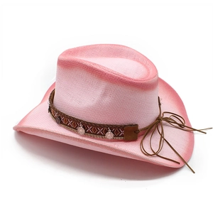 Detail of pink straw cowboy hat with ethnic style trim and silver metal charms