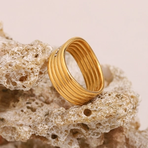 Anello a più strati ondulato placcato oro 18K con micro-cristalli su sfondo naturale