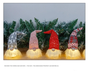 Detailed view of four glowing Christmas gnomes with LED lights and sequined hats