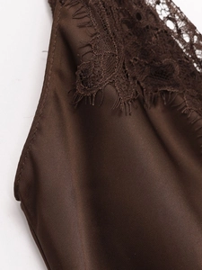 Detailed close-up of dark brown satin fabric featuring intricate delicate lace trim