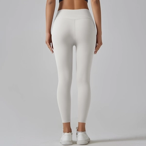Detail view of high-waist yoga leggings showing seamless hip-lifting stitching in ivory