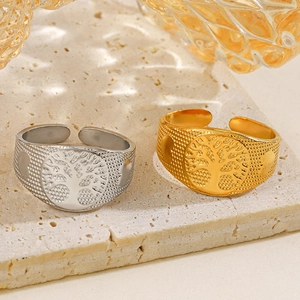 18k gold and silver tree of life adjustable rings on textured stone background