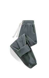 Dettaglio dei pantaloni sportivi in pile grigio spesso con coulisse elastica e tasche laterali