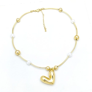 Detailed close-up of golden heart pendant necklace featuring white pearl beads