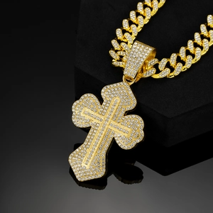 Detail of gold-plated iced out cross pendant and sparkling Cuban link chain necklace