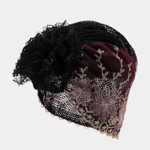 Detail of burgundy floral embroidery and black lace flower on fashion turban hat
