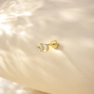 Detail of gold geometric earrings featuring double diamond-shaped studs with clear crystals