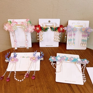 Detailed close-up of handmade Chinese flower hair clips with tassels and resin beads