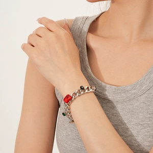 Detail of square rhinestone chain bracelet with red, green and black stones on wrist