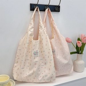 Détail de sacs fourre-tout à motifs d'ours avec étiquettes de marque sur crochets