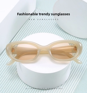 Detail of champagne oval sunglasses with UV protection on a blue textured background