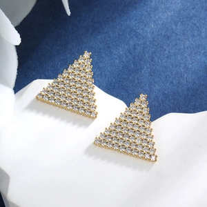 Detail of gold geometric triangle stud earrings with sparkling white cubic zirconia