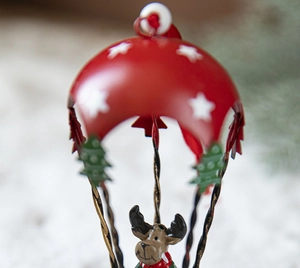 Detailed view of red metal Christmas parachute ornament with a small reindeer figure