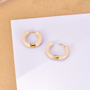 Détail de créoles minimalistes en émail beige avec placage en or 18 carats sur acier titane