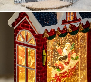 Macro shot of red Christmas house snow globe with Santa sleigh and LED lighting