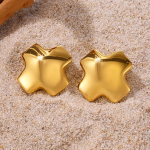 Boucles d'oreilles clous étoile en acier inoxydable doré sur fond de sable naturel