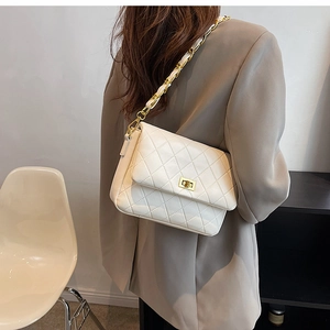 Close-up of quilted white PU leather bag with golden chain and twist-lock on model