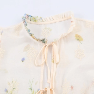 Beige French style embroidered blouse with floral patterns and tie-neck detail