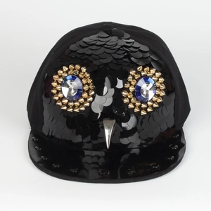 Detail of owl design on hiphop cap with black scales and blue gemstone eyes