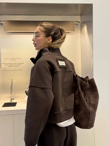 Close-up of brown oversized sweatshirt with UNITED EDITION patch and matching tote bag