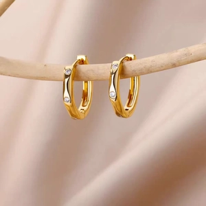 18k gold plated twist hoop earrings with sparkling cubic zirconia on a wooden branch