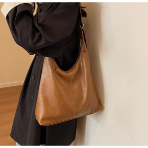 Close-up of soft brown leather tote bag with natural texture and adjustable strap