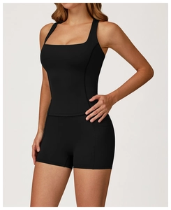 Dettaglio del top sportivo nero con scollo quadrato e pantaloncini con tasche laterali