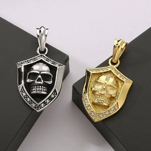 Detail of silver and gold skull shield pendants with rhinestones on black display