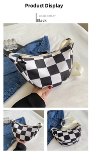Detail view of checkered crescent bag with black zipper and adjustable beige strap