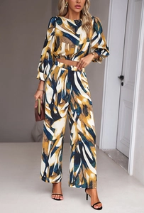 Detail of women's two-piece set featuring abstract print, puff sleeves and wide-leg trousers