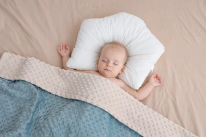 Dettaglio coperta per neonati blu e beige con punti 3D lenitivi e cuscino ergonomico morbido