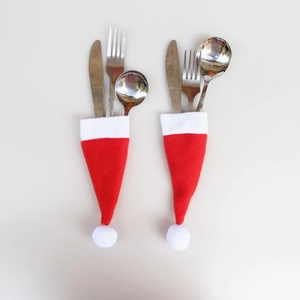 Détail de mini bonnets de Noël en peluche rouge pour porte-couverts avec couteau et fourchette