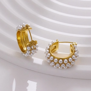 Detailed macro view of 18k gold plated C-shaped hoop earrings with inlaid white pearls