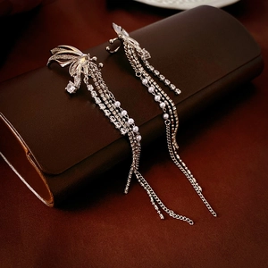 Macro detail of silver butterfly ear cuff with dangling tassel and sparkling zircons