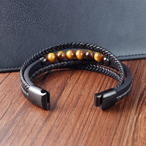 Gros plan sur bracelet homme en cuir avec perles oeil de tigre et fermoir aimanté