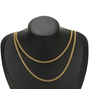 Polished gold stainless steel Cuban curb chain necklace on a black jewelry bust display