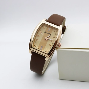 Detail of rose gold tonneau watch case with champagne striped dial and leather strap