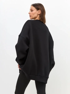 Back view of minimalist black oversized sweatshirt featuring loose fit and thick knit fabric